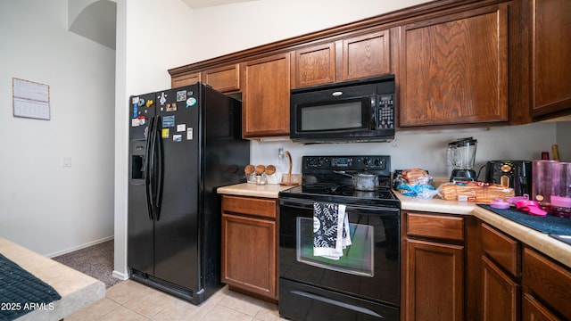 23941 N High Dunes Dr, Florence, AZ 85132 - kitchen with light countertops, brown cabinetry, light tile patterned floors, baseboards, and black appliances