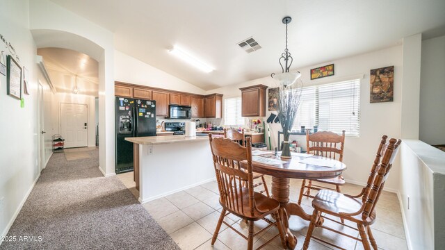 23941 N High Dunes Dr, Florence, AZ 85132 - dining space featuring light tile patterned flooring, visible vents, baseboards, arched walkways, and lofted ceiling
