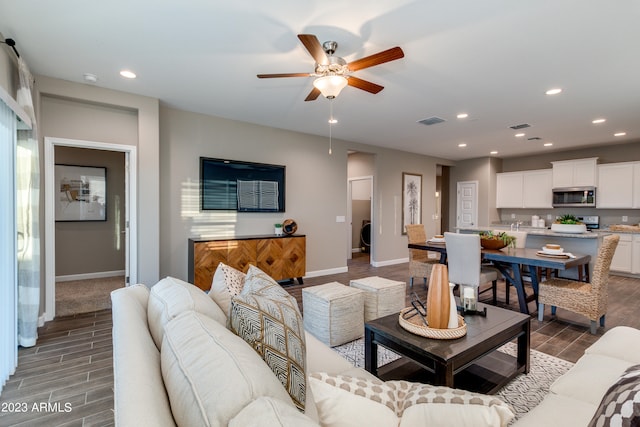 living room with ceiling fan and dark hardwood / wood-style floors