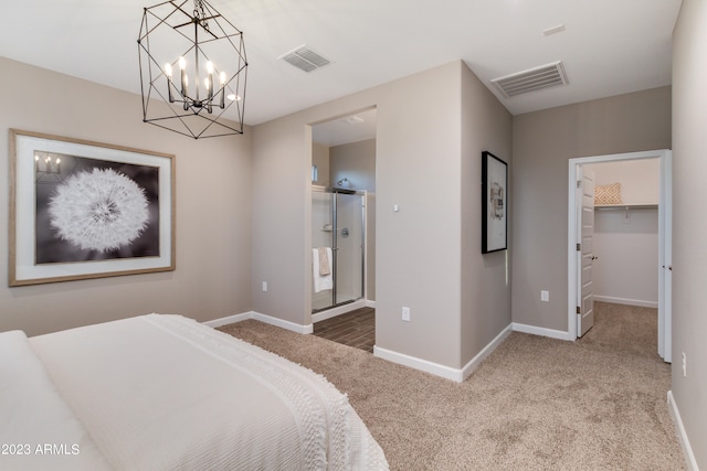 carpeted bedroom with ensuite bath, a closet, and a spacious closet