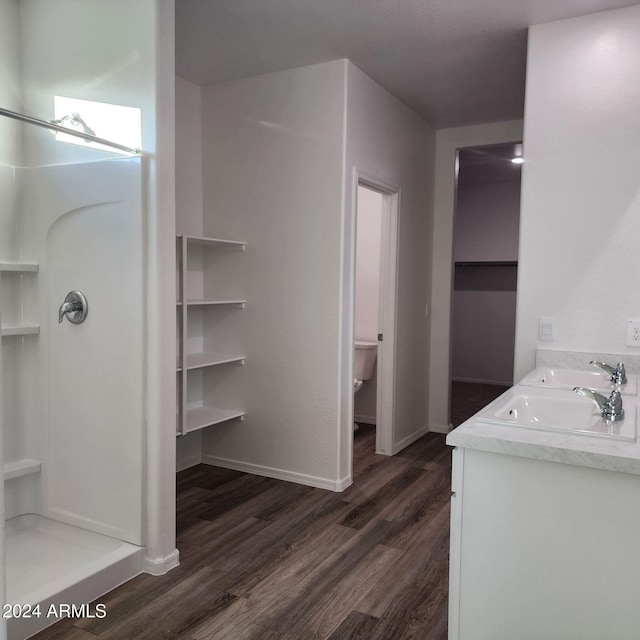 bathroom with toilet, vanity, hardwood / wood-style floors, and walk in shower