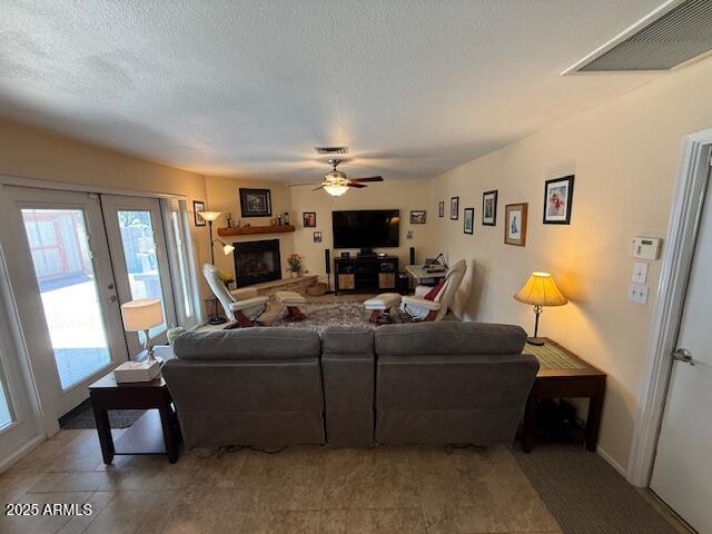 12601 N 34th St, Phoenix, AZ 85032 - living room featuring visible vents, a wealth of natural light, ceiling fan, and a fireplace with raised hearth
