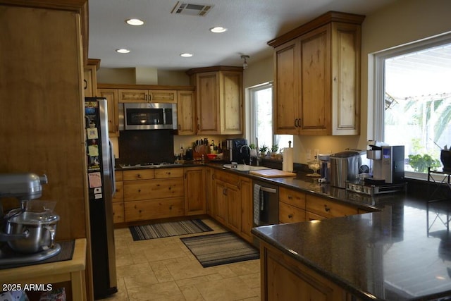 12601 N 34th St, Phoenix, AZ 85032 - kitchen with visible vents, a sink, dark countertops, brown cabinetry, and stainless steel appliances