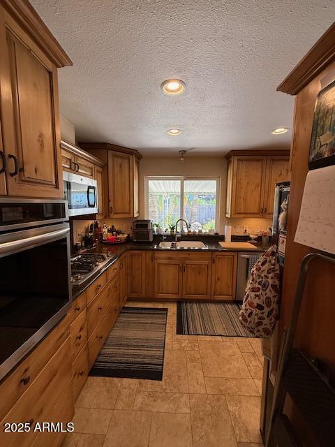 12601 N 34th St, Phoenix, AZ 85032 - kitchen with a sink, brown cabinets, a textured ceiling, and stainless steel appliances
