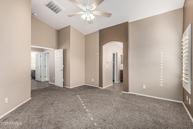 19576 N Portarosa Ct, Maricopa, AZ 85138 - spare room featuring arched walkways, ceiling fan, carpet flooring, baseboards, and vaulted ceiling