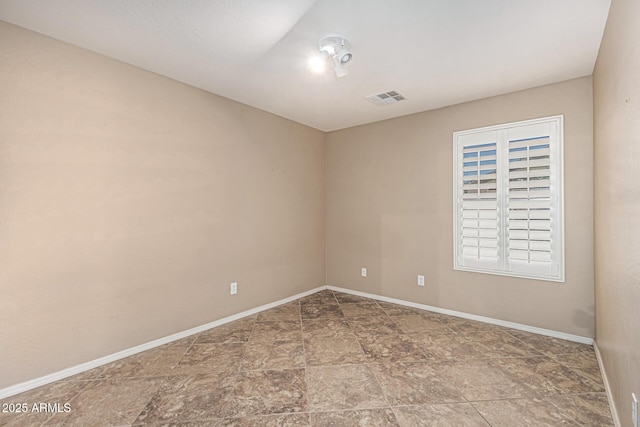 19576 N Portarosa Ct, Maricopa, AZ 85138 - spare room featuring stone finish flooring and baseboards