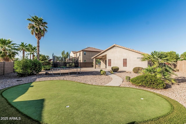 19576 N Portarosa Ct, Maricopa, AZ 85138 - fenced backyard with an area to practice putting, a trampoline, and a patio area