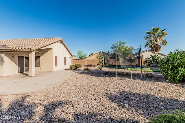 19576 N Portarosa Ct, Maricopa, AZ 85138 - fenced backyard featuring a trampoline and a patio