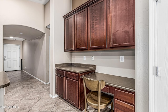 19576 N Portarosa Ct, Maricopa, AZ 85138 - office space featuring built in desk, arched walkways, baseboards, and light tile patterned floors