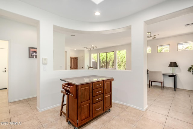 kitchen with light countertops, recessed lighting, light tile patterned flooring, and baseboards