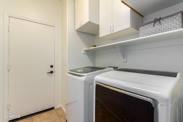 laundry room featuring cabinet space, light tile patterned flooring, and independent washer and dryer