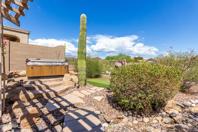 view of patio featuring a hot tub and fence