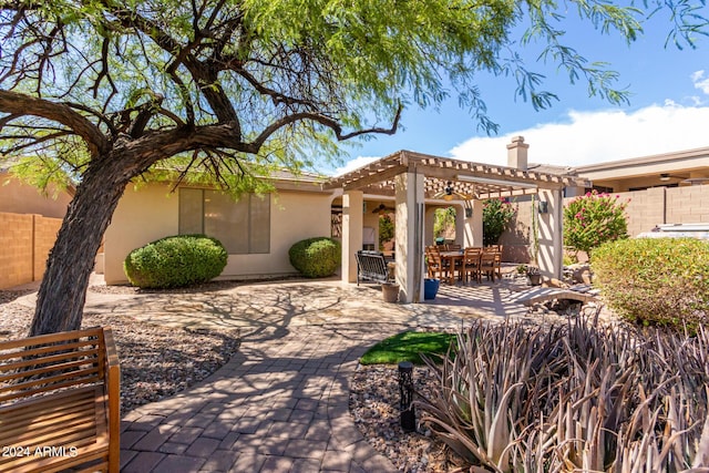 view of patio with outdoor dining space, fence, and a pergola