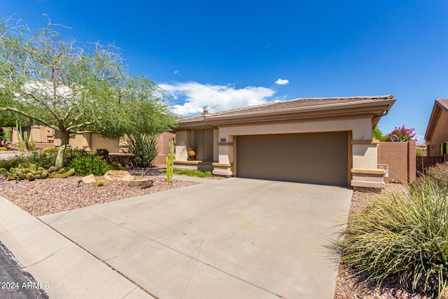 view of front of home featuring driveway, an attached garage, and stucco siding