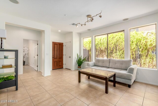 living area with light tile patterned floors, plenty of natural light, and visible vents