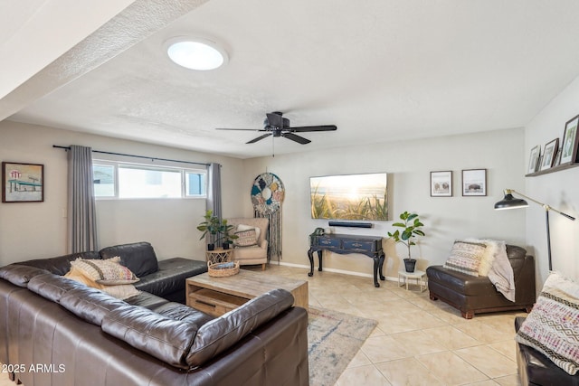 living room featuring ceiling fan, light tile patterned flooring, and a textured ceiling