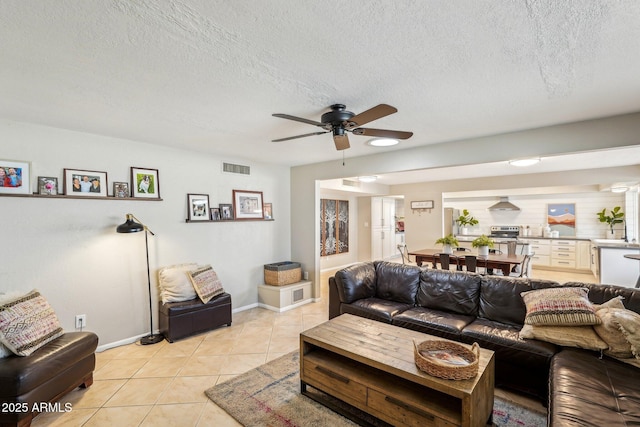 tiled living room featuring ceiling fan and a textured ceiling