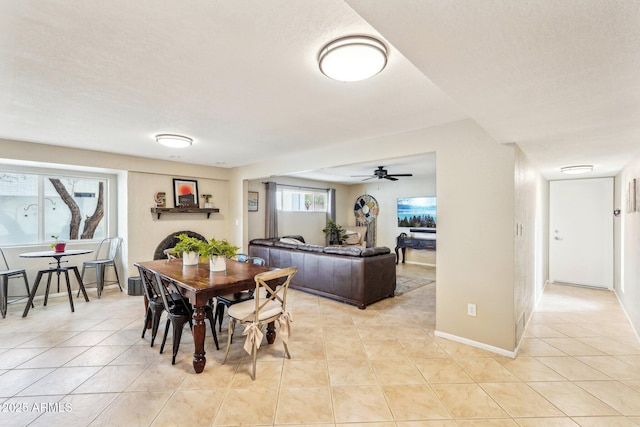 dining area featuring light tile patterned floors, a textured ceiling, and ceiling fan