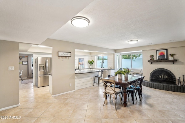 dining space with light tile patterned floors and a textured ceiling