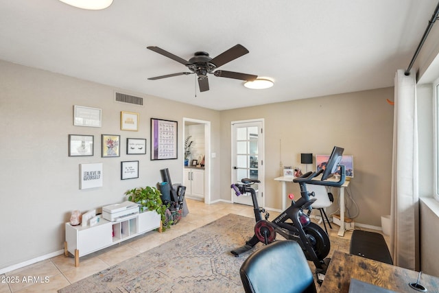 workout room featuring ceiling fan and light tile patterned floors