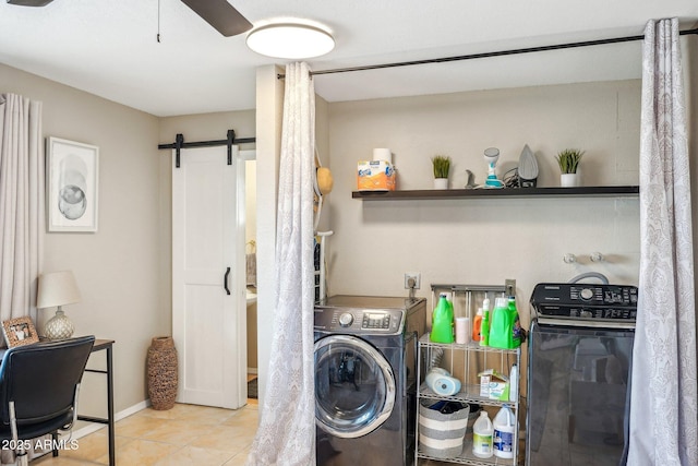 washroom featuring a barn door, ceiling fan, light tile patterned floors, and washer / dryer