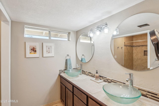 bathroom featuring vanity, a textured ceiling, and walk in shower