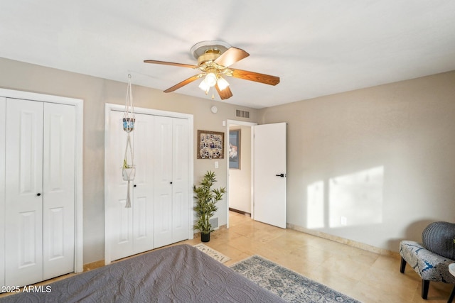 bedroom with ceiling fan and two closets