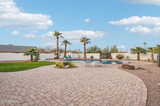 view of patio featuring a fenced in pool and a storage shed