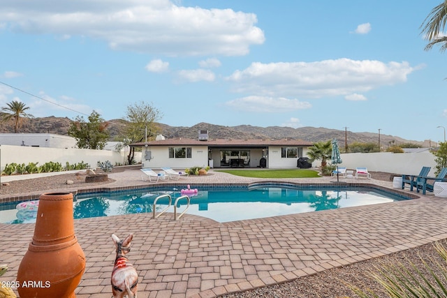 view of swimming pool with a mountain view and a patio area