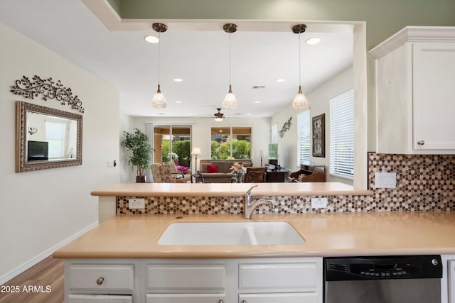 kitchen featuring white cabinetry, a sink, light countertops, dishwasher, and tasteful backsplash