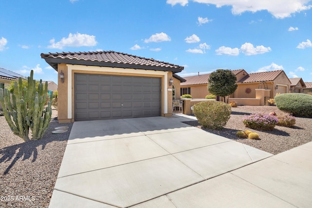 view of front facade with a tile roof, stucco siding, an attached garage, and concrete driveway