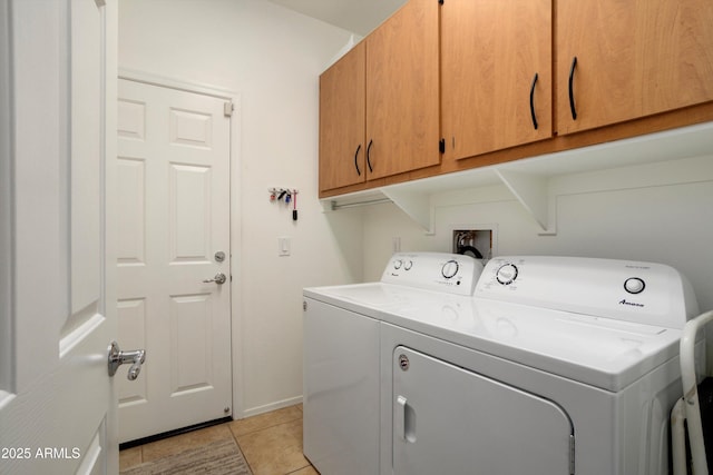 laundry room featuring cabinet space, washing machine and dryer, and light tile patterned flooring