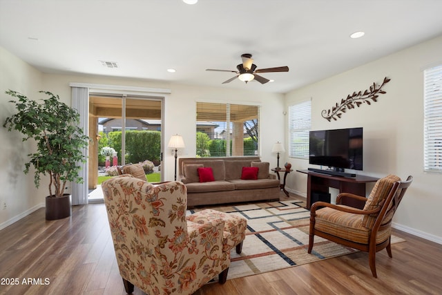 living area featuring visible vents, baseboards, recessed lighting, wood finished floors, and a ceiling fan