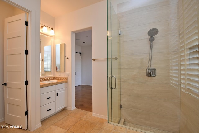 bathroom featuring tile patterned floors, walk in shower, and vanity