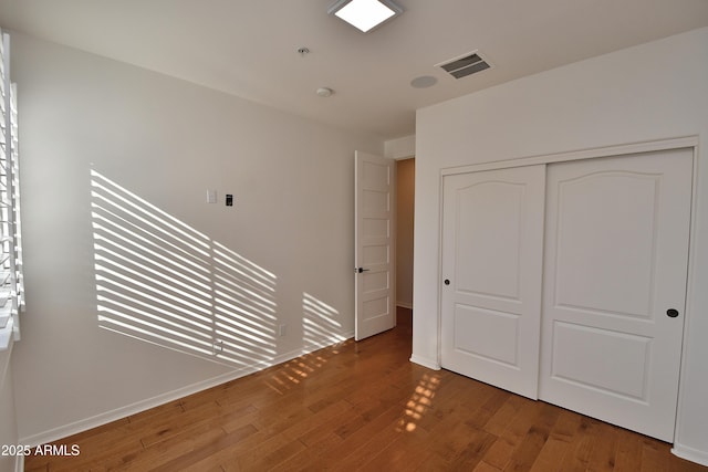 unfurnished bedroom featuring a closet and wood-type flooring