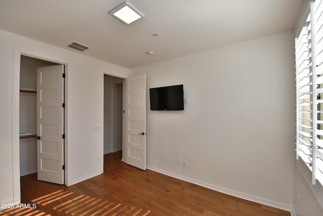 unfurnished bedroom featuring a closet and dark hardwood / wood-style floors