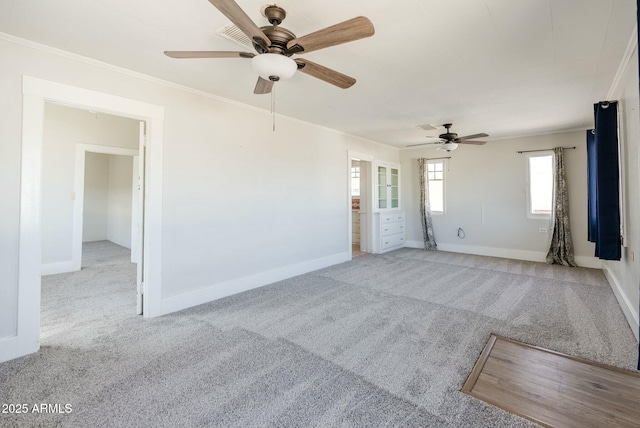 unfurnished room featuring carpet floors, baseboards, a ceiling fan, and ornamental molding