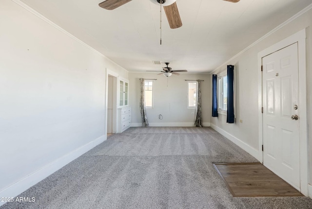 unfurnished living room with baseboards, ceiling fan, carpet flooring, and ornamental molding