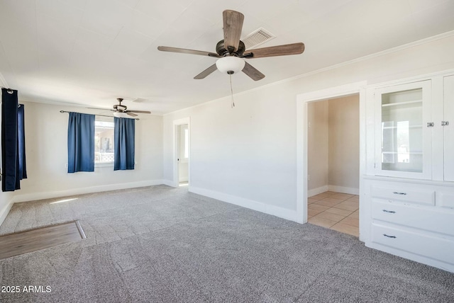 spare room featuring baseboards, a ceiling fan, carpet, and ornamental molding
