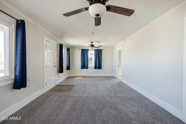 spare room featuring baseboards, carpet floors, ceiling fan, and crown molding