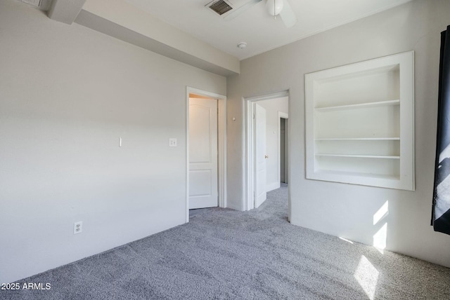 carpeted empty room featuring visible vents and a ceiling fan