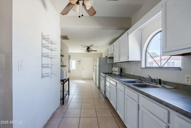 kitchen featuring a sink, white appliances, a ceiling fan, and light tile patterned floors