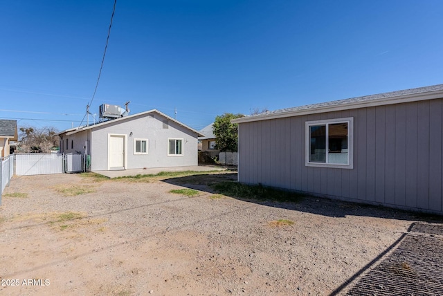 view of side of home with a gate, central AC, and fence