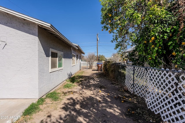view of property exterior with fence and stucco siding