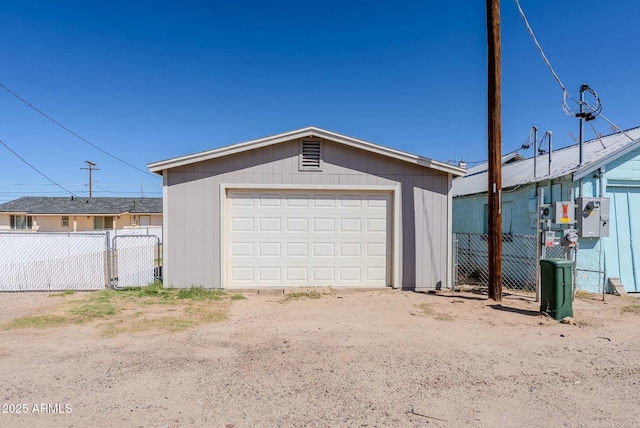 detached garage with a gate and fence