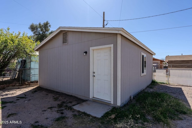 view of outdoor structure with an outbuilding, a gate, and fence