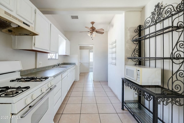 kitchen featuring white appliances, light tile patterned floors, a ceiling fan, visible vents, and under cabinet range hood