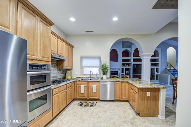 kitchen featuring a sink, visible vents, appliances with stainless steel finishes, and a peninsula