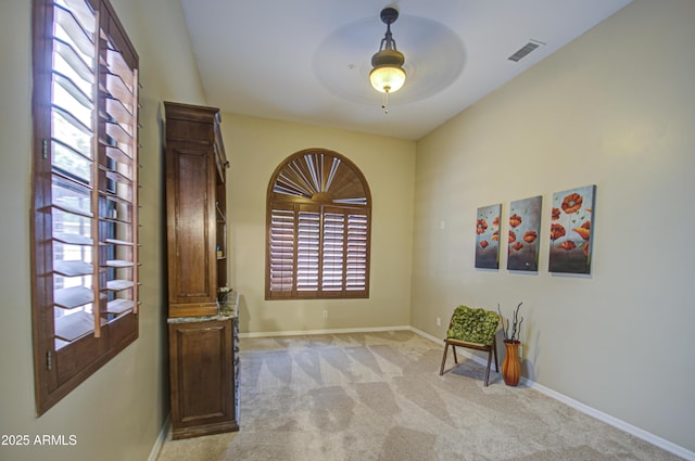 sitting room featuring light colored carpet, visible vents, and baseboards