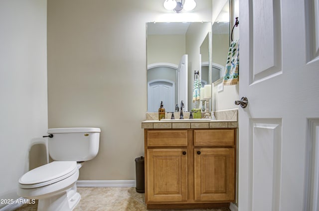 bathroom with tile patterned flooring, toilet, vanity, and baseboards